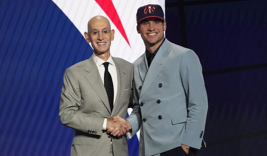 Corey Kispert, right, poses for a photo with NBA Commissioner Adam Silver after being selected 15th overall by the Washington Wizards during the NBA basketball draft, Thursday, July 29, 2021, in New York. (AP Photo/Corey Sipkin)