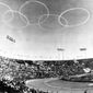 FILE - In this Oct. 10, 1964, file photo, vapor trails from Japanese Self-Defense Force jets form the Olympic emblem of the five rings above the National Stadium in Tokyo for the official opening of the XVIII Olympiad, first even held in Asia. Every Japanese of a certain age has memories of the 1964 Tokyo Olympics. Even younger Japanese have connections through parents or aunts and uncles who saved old photos, faded certificates, or recall getting a television for the first time to watch the Games. (AP Photo, File)