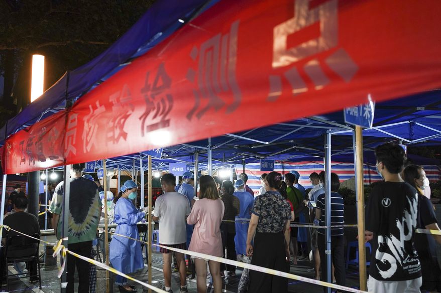 In this photo released by China's Xinhua News Agency, people line up for COVID-19 tests at a testing station in Nanjing in eastern China's Jiangsu Province, Wednesday, July 28, 2021. Roadblocks were set up to check drivers and a disease-control official called Thursday for increased testing of workers at Chinese ports after a rash of coronavirus cases traced to a major airport rattled authorities who thought they had the disease under control. (Li Bo/Xinhua via AP)