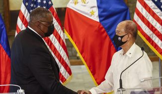 United States Defense Secretary Lloyd Austin, left, and Philippines Defense Secretary Delfin Lorenzana shake hands after a bilateral meeting at Camp Aguinaldo military camp in Quezon City, Metro Manila, Philippines Friday, July 30, 2021. Austin is visiting Manila to hold talks with Philippine officials to boost defense ties and possibly discuss the The Visiting Forces Agreement between the US and Philippines. (Rolex dela Pena/Pool Photo via AP)