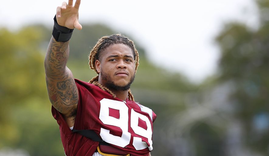 Chase Young (99) waves to the crowd at the Washington Football Team&#x27;s NFL training camp Saturday, July 31, 2021, in Richmond, Va. (AP Photo/Dean Hoffmeyer)