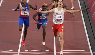 Patrick Grzegorzewicz of Poland celebrates as he crosses the finish line to win the 4 x 400-meter mixed relay at the 2020 Summer Olympics, Saturday, July 31, 2021, in Tokyo. (AP Photo/Charlie Riedel)