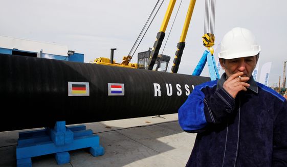 In this Friday, April 9, 2010, file photo, a Russian construction worker smokes in Portovaya Bay some 170 kms (106 miles) northwest from St. Petersburg, Russia, during a ceremony marking the start of Nord Stream pipeline construction. (AP Photo/Dmitry Lovetsky, File)