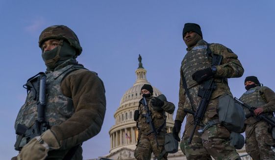 In this Jan. 19, 2021, photo, National Guard troops reinforce the security zone on Capitol Hill in Washington. Over the past year, National Guard members have been called in to battle the COVID-19 pandemic, natural disasters and race riots. (AP Photo/J. Scott Applewhite) **FILE**