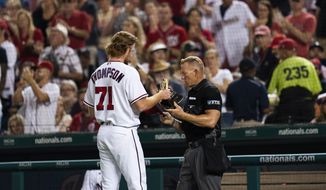 Home plate umpire checks Washington Nationals pitcher Mason Thompson&#39;s (71) cap and glove at the end of the sixth inning during a baseball game against the Philadelphia Phillies in Washington, Monday, Aug. 2, 2021. (AP Photo/Manuel Balce Ceneta)