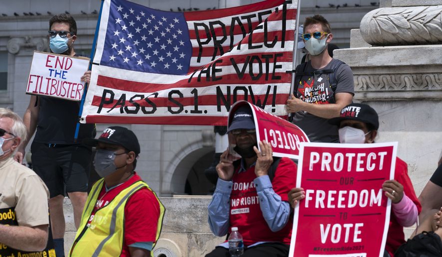 Voting rights activists hold signs and banners during a demonstration supporting voting rights during a rally on Capitol Hill, in Washington, Monday, Aug. 2, 2021. (AP Photo/Jose Luis Magana)