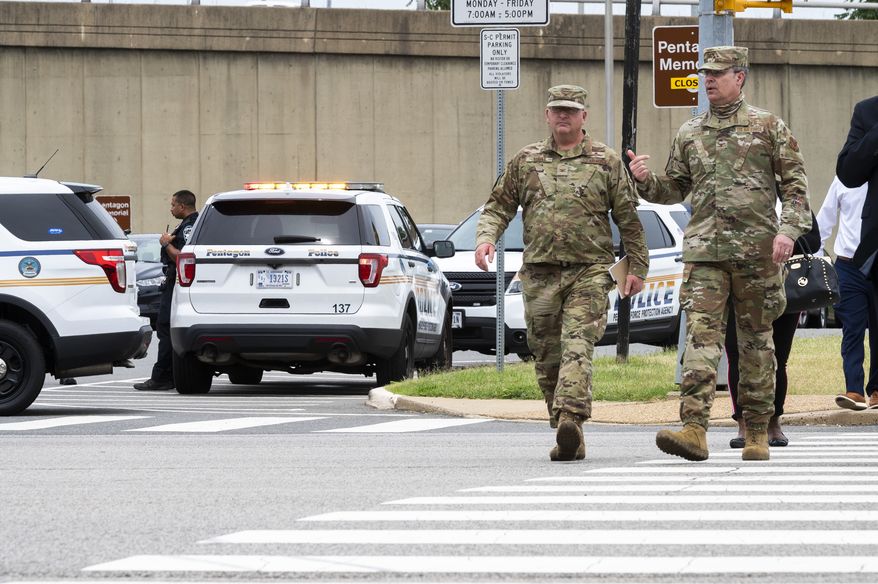 Members of the Air Force walk away from the Pentagon, Tuesday, Aug. 3, 2021, in Washington. Gunshots were fired Tuesday morning near the entrance of the Pentagon, resulting in multiple injuries. The facility, the headquarters of the U.S. military, was temporarily placed on lockdown. The Arlington County Fire Department reported multiple patients, but it wasn't immediately clear if they had been shot and the extent of their injuries were unknown. (AP Photo/Cliff Owen)