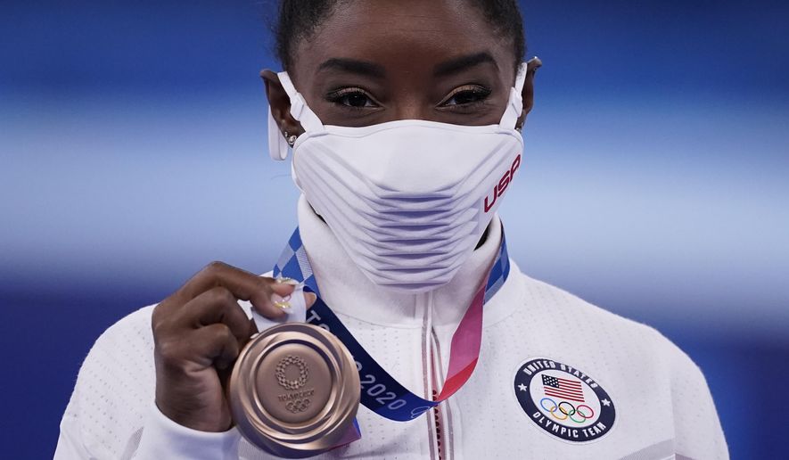 Simone Biles, of the United States, poses with her bronze medal after balance beam competition during the artistic gymnastics women&#39;s apparatus final at the 2020 Summer Olympics, Tuesday, Aug. 3, 2021, in Tokyo, Japan. (AP Photo/Ashley Landis)