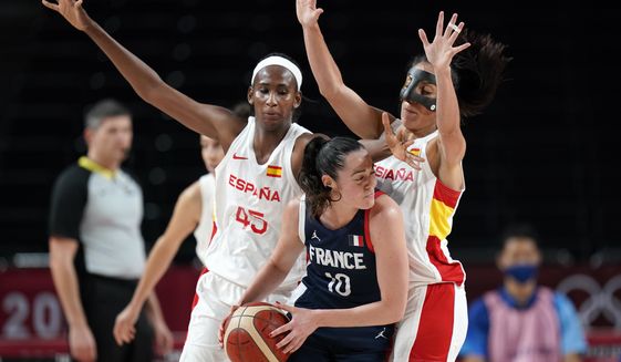 France&#39;s Sarah Michel (10) looks to pass around Spain&#39;s Astou Ndour (45) and Cristina Ouvina, right, during a women&#39;s basketball quarterfinal round game at the 2020 Summer Olympics, Wednesday, Aug. 4, 2021, in Saitama, Japan. (AP Photo/Eric Gay)