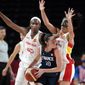 France&#39;s Sarah Michel (10) looks to pass around Spain&#39;s Astou Ndour (45) and Cristina Ouvina, right, during a women&#39;s basketball quarterfinal round game at the 2020 Summer Olympics, Wednesday, Aug. 4, 2021, in Saitama, Japan. (AP Photo/Eric Gay)