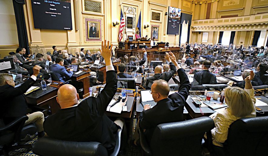 Republican members of the House of Delegates raise their hands to call for a recorded vote on the budget bill at the Virginia State Capitol in Richmond, Va., Tuesday, Aug. 3, 2021, on the second day of the General Assembly Special Session. (Bob Brown/Richmond Times-Dispatch via AP)