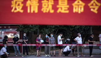 In this file photo, residents line up for Covid-19 tests near a banner with the words &#39;Epidemic is the Order&#39; in Wuhan in central China&#39;s Hubei province Tuesday, Aug. 3, 2021. China&#39;s worst coronavirus outbreak since the start of the pandemic a year and a half ago escalated Wednesday with dozens more cases around the country, the sealing-off of one city and the punishment of its local leaders. (Chinatopix Via AP)  **FILE**
