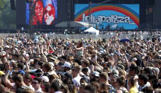 In this July 29, 2021 file photo, fans gather and cheer on day one of the Lollapalooza music festival at Grant Park in Chicago. (AP Photo/Shafkat Anowar File)