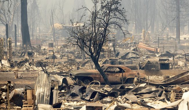 Homes and cars destroyed by the Dixie Fire line central Greenville on Thursday, Aug. 5, 2021, in Plumas County, Calif. (AP Photo/Noah Berger)