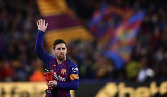 In this Saturday, April 6, 2019, photo, Barcelona forward Lionel Messi waves at the crowd as he holds the trophy of the best Spanish La Liga player prior to a soccer match between FC Barcelona and Atletico Madrid at the Camp Nou stadium in Barcelona, Spain. Barcelona says Lionel Messi will not stay with the club, it was reported on Aug. 5, 2021, in a statement that a deal between the club and the player had been reached but financial “obstacles” made it impossible for the player to remain with the club.  (AP Photo/Manu Fernandez) **FILE**