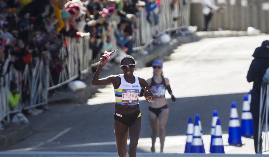 FILE - In this Feb. 29, 2020, file photo, first place finisher Aliphine Tuliamuk leads second place finisher Molly Seidel to the finish in the U.S. Olympic marathon trials in Atlanta. Tuliamuk will have company in Tokyo with her baby, Zoe, allowed to travel with her. The original plan was to start a family after the Tokyo Olympics. But when the Summer Games were postponed by the pandemic, the 32-year-old Tuliamuk and her fiance, Tim Gannon, decided not to wait. (AP Photo/John Amis, File)
