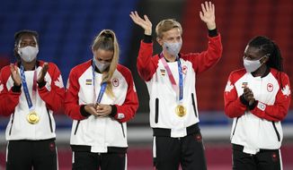 Canada&#39;s Quinn, second right, waves during the medal ceremony after beating Sweden in the women&#39;s final soccer match at the 2020 Summer Olympics, Saturday, Aug. 7, 2021, in Yokohama, Japan. (AP Photo/Andre Penner)