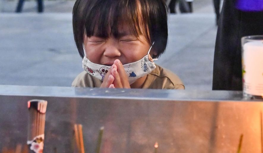 A child prays in front of the cenotaph dedicated to the victims of the atomic bombing at the Hiroshima Peace Memorial Park in Hiroshima, western Japan Friday, Aug. 6, 2021. Hiroshima on Friday marked the 76th anniversary of the world&#39;s first atomic bombing of the city. (Kyodo News via AP)