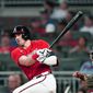 Atlanta Braves&#39; Adam Duvall, left, drives in a run with a double as Washington Nationals catcher Tres Barrera looks on in the fifth inning of a baseball game Friday, Aug. 6, 2021, in Atlanta. (AP Photo/John Bazemore)
