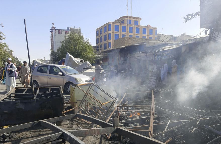 Smoke rises from damaged shops after fighting between Taliban and Afghan security forces in Kunduz city, northern Afghanistan, Sunday, Aug. 8, 2021. Taliban fighters Sunday took control of much of the capital of Kunduz province, including the governor's office and police headquarters, a provincial council member said. (AP Photo/Abdullah Sahil)