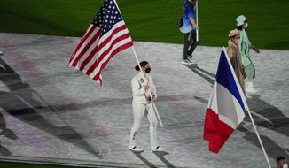 Kara Winger, of the United States of America, and Steven Da Costa, of France, carry their country&#39;s flags during the closing ceremony in the Olympic Stadium at the 2020 Summer Olympics, Sunday, Aug. 8, 2021, in Tokyo, Japan. (AP Photo/Vincent Thian)