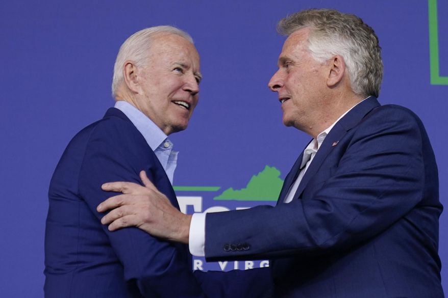 In this July 23, 2021, file photo, President Joe Biden greets Virginia Democratic gubernatorial candidate Terry McAuliffe as he arrives to speak at a campaign event for McAuliffe at Lubber Run Park, in Arlington, Va. (AP Photo/Andrew Harnik, File)