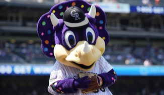 FILE - Colorado Rockies mascot Dinger in shown in the first inning of a baseball game in Denver, in this Sunday, July 18, 2021, file photo. The Colorado Rockies said a fan suspected of repeatedly yelling a racial slur at Florida outfielder Lewis Brinson was actually hollering at “Dinger,” the club&#39;s purple, polka-dotted dinosaur mascot. The team said Monday, Aug. 9, 2021, that fans who were seated nearby contacted the club in defense of the fan after it put out a statement saying it was disgusted by epithets hurled at Brinson when he was up in the ninth inning of Colorado&#39;s 13-8 victory Sunday. The club then contacted the fan, who explained it was just a big misunderstanding and that he was only trying to get the attention of Dinger, who was two sections over. (AP Photo/David Zalubowski, File)