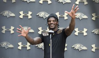 Baltimore Ravens quarterback Lamar Jackson answers questions from reporters after an NFL football practice, Monday, Aug. 9, 2021 in Owings Mills, Md.(AP Photo/Gail Burton)