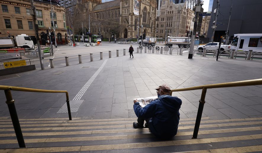 A man reads a newspaper on the steps of Flinders Street Station in Melbourne, Australia, Wednesday, Aug. 11, 2021. Australia&#39;s second-largest city has extended its lockdown in a bid to eliminate COVID-19 while authorities in Sydney flagged restrictions easing for vaccinated residents despite the delta variant continuing to spread. (AAP Image/Daniel Pockett)