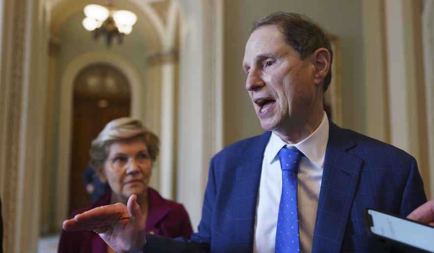 In this July 21, 2021, photo Sen. Ron Wyden, D-Ore., chair of the Senate Finance Committee, joined at left by Sen. Elizabeth Warren, D-Mass., talks about their discussions on the national debt with Senate Majority Leader Chuck Schumer, D-N.Y., at the Capitol in Washington. (AP Photo/J. Scott Applewhite) **FILE**