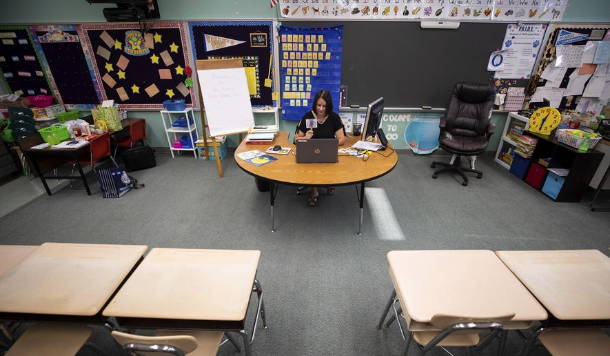 In this Aug. 27, 2020, file photo, a teacher conducts a virtual lesson in her empty classroom on the first day of classes in Blakely, Pa.  (Christopher Dolan/The Times-Tribune via AP) **FILE**