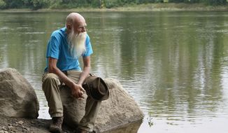 David Lidstone, 81, sits for a photograph near the Merrimack River, Tuesday, Aug. 10, 2021, in Boscawen, N.H. Lidstone, an off-the-grid New Hampshire hermit known to locals as &amp;quot;River Dave,&amp;quot; had been living in a cabin in the woods along the Merrimack River, in Canterbury, N.H., for nearly three decades. He was jailed July 15, 2021 on a civil contempt sanction and was told he&#39;d be released if he agreed to leave the cabin, that has since burnt down. (AP Photo/Steven Senne)