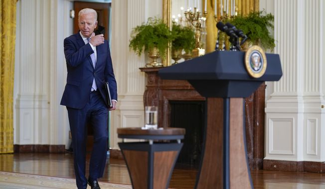 President Joe Biden removes his face mask as he arrives to speak in the East Room of the White House, Thursday, Aug. 12, 2021, in Washington. (AP Photo/Evan Vucci)