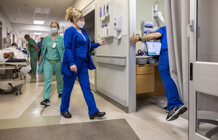 Running from room to room, emergency room director Mark Kellar, right, hurries between patients at Our Lady of Angels Hospital in Bogalusa, La., Monday, Aug. 9, 2021. (Chris Granger/The Advocate via AP)