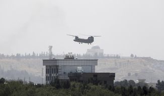 A U.S. Chinook helicopter flies near the U.S. Embassy in Kabul, Afghanistan, Sunday, Aug. 15, 2021. Helicopters are landing at the U.S. Embassy in Kabul as diplomatic vehicles leave the compound amid the Taliban advanced on the Afghan capital. (AP Photo/Rahmat Gul)