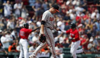 Baltimore Orioles&#39; Keegan Akin walks back to the mound after giving up a three-run home run to Boston Red Sox&#39;s J.D. Martinez, right, during the first inning of a baseball game, Sunday, Aug. 15, 2021, in Boston. (AP Photo/Michael Dwyer)