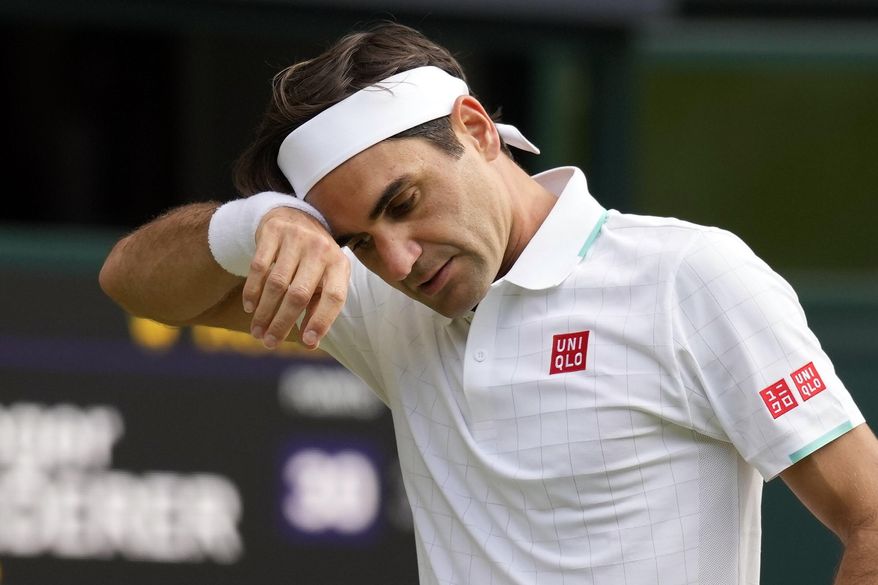 In this July 7, 2021, file photo, Switzerland&#39;s Roger Federer wipes his brow during the men&#39;s singles quarterfinals match against Poland&#39;s Hubert Hurkacz on day nine of the Wimbledon Tennis Championships in London. Federer pulled out of the upcoming hard-court tournaments in Toronto and Cincinnati on Thursday, Aug. 5, 2021, citing lingering issues with his surgically repaired knee and shedding doubt on his status for the U.S. Open. (AP Photo/Kirsty Wigglesworth, File) **FILE**
