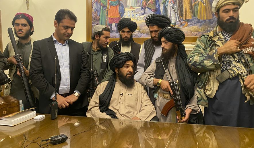Taliban fighters take control of Afghan presidential palace after the Afghan President Ashraf Ghani fled the country, in Kabul, Afghanistan, Sunday, Aug. 15, 2021. Person second from left is a former bodyguard for Ghani. (AP Photo/Zabi Karimi)