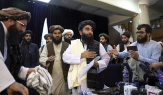 Taliban spokesman Zabihullah Mujahid, center, leaves after his first news conference, in Kabul, Afghanistan, Tuesday, Aug. 17, 2021. Mujahid vowed Tuesday that the Taliban would respect women&#39;s rights, forgive those who resisted them and ensure a secure Afghanistan as part of a publicity blitz aimed at convincing world powers and a fearful population that they have changed. (AP Photo/Rahmat Gul)