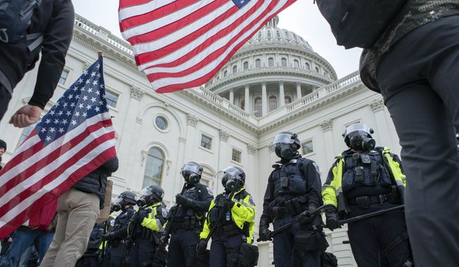 U.S. Capitol police push back supporters of President Donald Trump who try to break a door on the West side of the U.S. Capitol on Wednesday, Jan. 6, 2021, in Washington. (AP Photo/Jose Luis Magana)