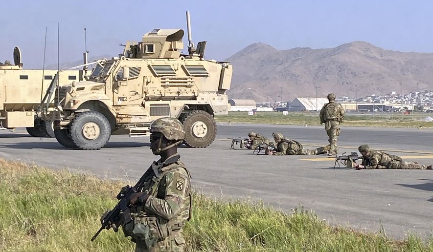 U.S soldiers stand guard along a perimeter at the international airport in Kabul, Afghanistan, Monday, Aug. 16, 2021. On Monday, the U.S. military and officials focus was on Kabul&#x27;s airport, where thousands of Afghans trapped by the sudden Taliban takeover rushed the tarmac and clung to U.S. military planes deployed to fly out staffers of the U.S. Embassy, which shut down Sunday, and others. (AP Photo/Shekib Rahmani)