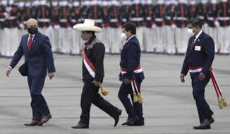 Peru&#39;s President Pedro Castillo, second from left, is followed by Prime Minister Guido Bellido and Defense Minister Walter Ayala at a military parade in Lima, Peru, Friday, July 30, 2021. (AP Photo/Guadalupe Pardo)