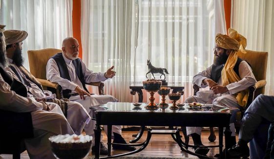 In this handout photograph released by the Taliban, former Afghan President Hamid Karzai, center left, senior Haqqani group leader Anas Haqqani, right, meet in Kabul, Afghanistan, Wednesday, Aug. 18, 2021. The meeting comes after the Taliban&#39;s lightning offensive saw the militants seize the capital, Kabul. (Taliban via AP)
