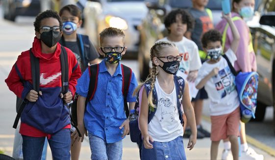 FILE - In this Tuesday, Aug. 10, 2021 file photo, Students, some wearing protective masks, arrive for the first day of school at Sessums Elementary School in Riverview, Fla. President Joe Biden has called school district superintendents in Florida and Arizona, praising them for doing what he called “the right thing” after their respective boards implemented mask requirements in defiance of their Republican governors amid growing COVID-19 infections. (AP Photo/Chris O&#39;Meara, File)