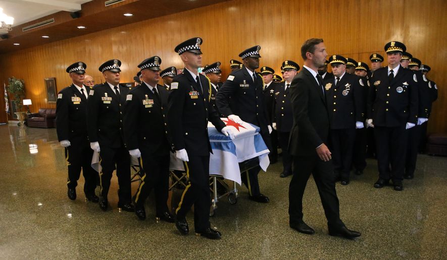 In this file photo, the casket of Chicago police Officer Ella French is brought through the vestibule before the funeral service for French on Thursday, Aug. 19, 2021, at St. Rita of Cascia Shrine Chapel in Chicago.  French was killed and her partner was seriously wounded during an Aug. 7 traffic stop on the city&#39;s South Side. The National Fraternal Order of Police on Jan. 3, 2022, released a report showing 63 officers were gunned down while on the job in 2021, up from 47 in 2020, 50 in 2019 and 53 in 2018.(Antonio Perez/Chicago Tribune via AP, Pool)