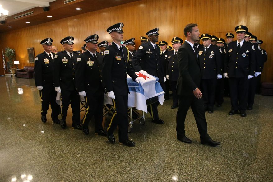 In this file photo, the casket of Chicago police Officer Ella French is brought through the vestibule before the funeral service for French on Thursday, Aug. 19, 2021, at St. Rita of Cascia Shrine Chapel in Chicago.  French was killed and her partner was seriously wounded during an Aug. 7 traffic stop on the city&#x27;s South Side. The National Fraternal Order of Police on Jan. 3, 2022, released a report showing 63 officers were gunned down while on the job in 2021, up from 47 in 2020, 50 in 2019 and 53 in 2018.(Antonio Perez/Chicago Tribune via AP, Pool)