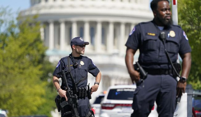 U.S. Capitol Police officers stand at an intersection near the U.S. Capitol and a Library of Congress building in Washington on Thursday, Aug. 19, 2021, as law enforcement investigate a report of a possible explosive device in a pickup truck outside the Library of Congress on Capitol Hill and have evacuated have evacuated multiple buildings on the sprawling Capitol complex. (AP Photo/Patrick Semansky)