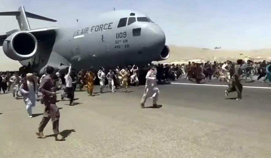 In this Aug. 16, 2021, photo, hundreds of people run alongside a U.S. Air Force C-17 transport plane as it moves down a runway of the international airport, in Kabul, Afghanistan. (Verified UGC via AP) **FILE**