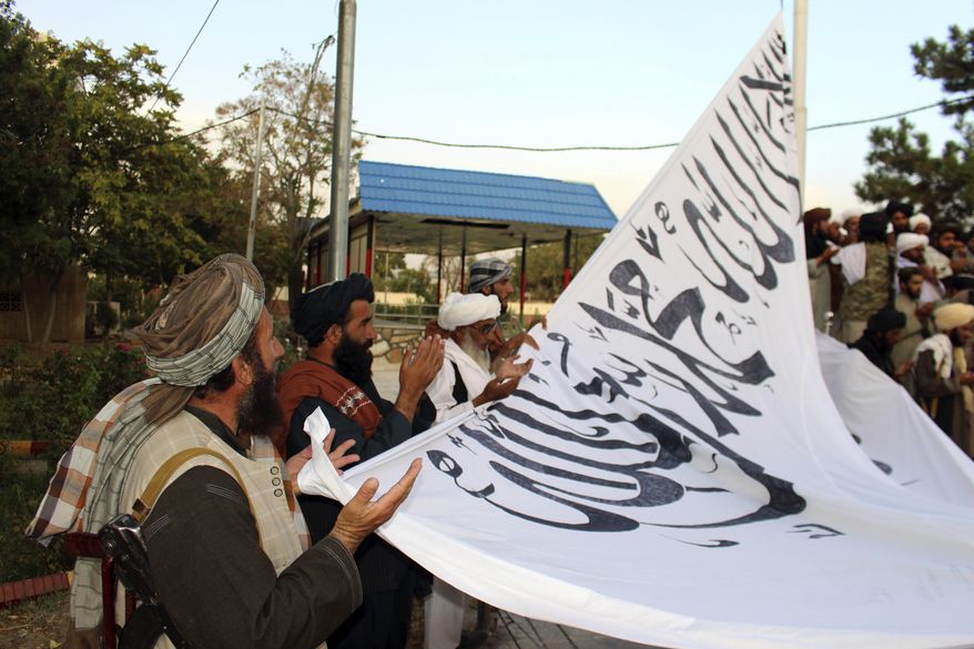 In this Aug. 15, 2021, photo, Taliban fighters pray while raising their flag at the Ghazni provincial governor&#x27;s house, in Ghazni, southeastern, Afghanistan. (AP Photo/Gulabuddin Amiri) **FILE**