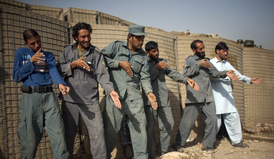 In this file photo from October 2010, Afghan policemen simulate weapons orientation during a training session with U.S. soldiers from 2nd PLT Diablos 552nd Military Police Company, on the outskirts of Kandahar City, Afghanistan. (AP Photo/Rodrigo Abd) ** FILE **